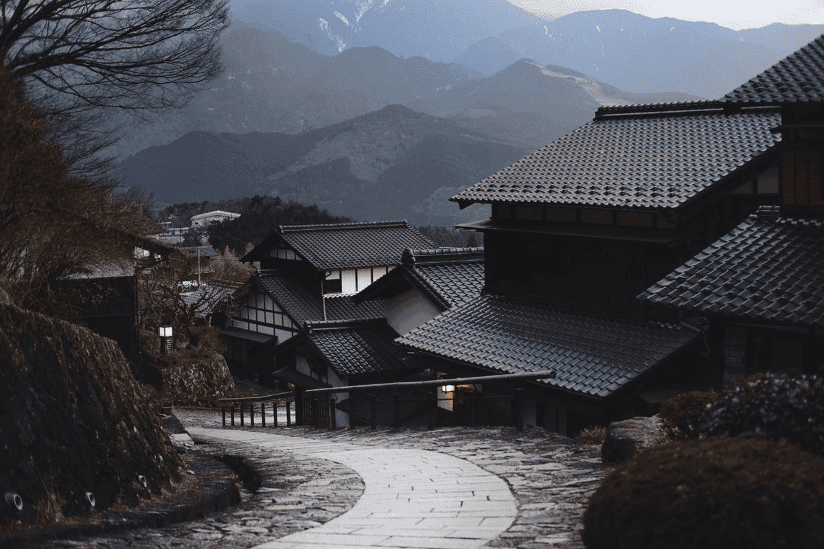 瓦屋根と曲がりくねった石畳の道がある山村